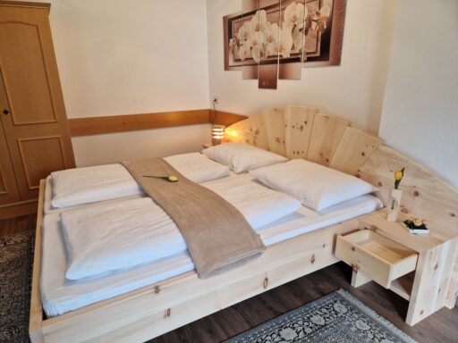Zirbenbett Modell 7 mit Astkopfteil, Gesamtansicht im Schlafzimmer