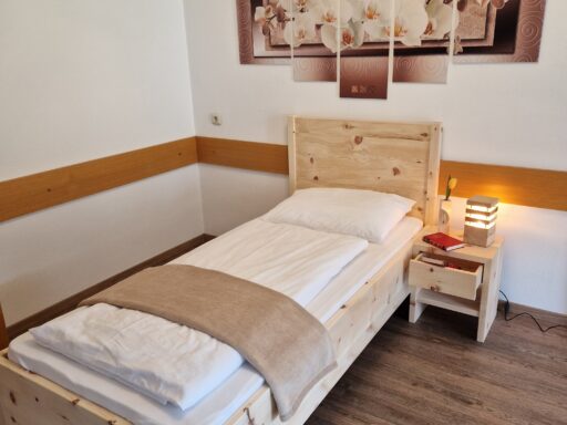 Zirbenbett 6 als Einzelbett in einem hellen Schlafzimmer