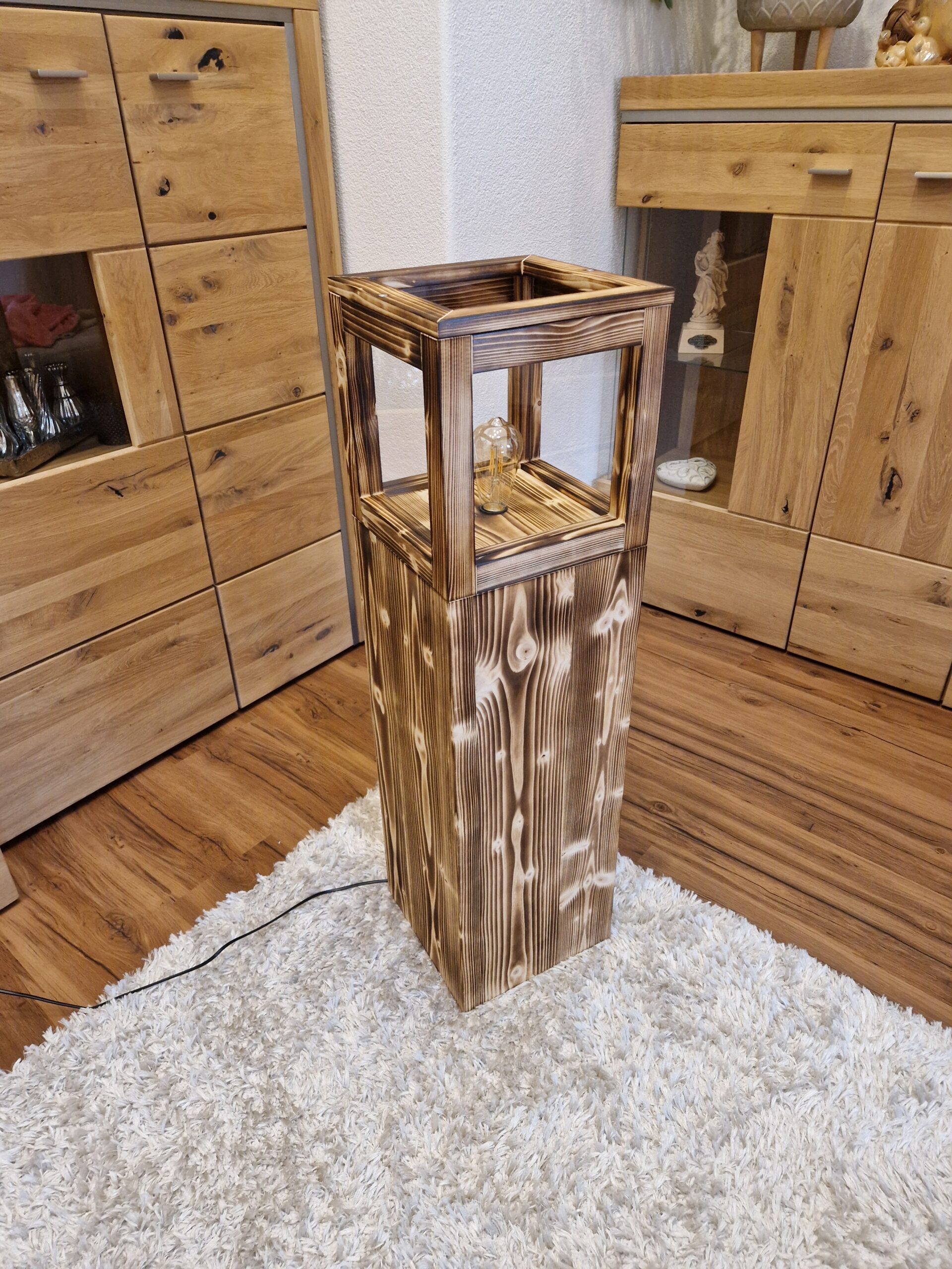 Stehlampe Flame aus Zirbenholz, seitliche Ansicht mit Lichtschein
