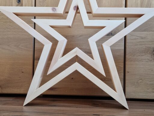 Weihnachtsstern aus Zirbenholz, weiß lasiert, an einer Holzwand