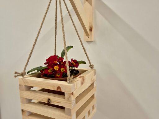Blumenampel aus Zirbenholz an Juteseilen, seitliche Ansicht mit blühender Primel