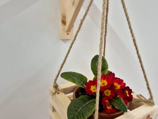 Blumenampel aus Zirbenholz in Nahaufnahme, Lattenkorb an geknoteten Seilen