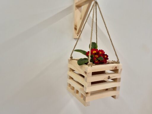 Blumenampel aus Zirbenholz an heller Wand, Gesamtansicht mit Halterung