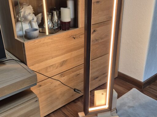 Stehlampe aus Zirbenholz mit Lichtrahmen vor einem Schrank