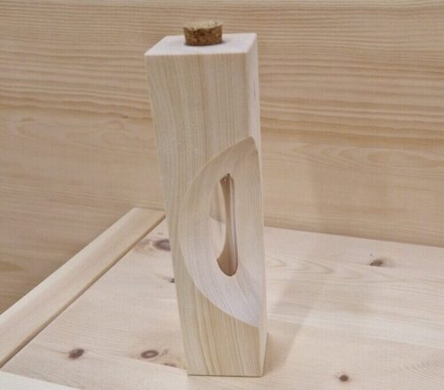 Zirbenvase mit geschwungenem Ausschnitt vor heller Holzwand