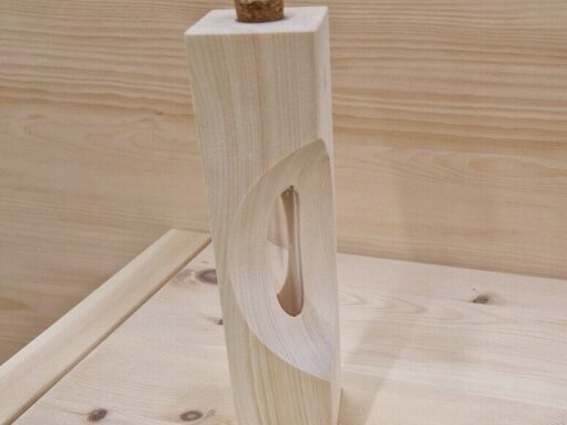 Zirbenvase mit geschwungenem Ausschnitt vor heller Holzwand