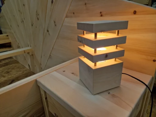 Beleuchtete Nachttischlampe aus Zirbenholz auf einem Nachtkästchen