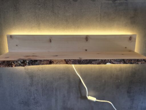 Beleuchtetes Wandregal aus Zirbenholz an einer dunklen Wand
