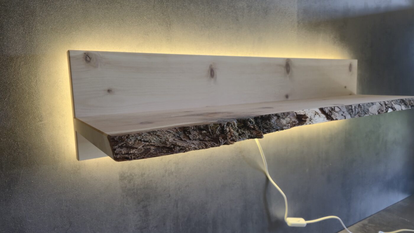 Beleuchtetes Wandregal aus Zirbenholz mit Baumkante an einer Wand