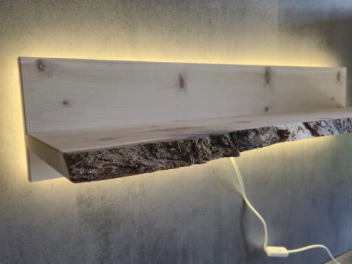 Beleuchtetes Wandregal aus Zirbenholz mit Baumkante an einer Wand