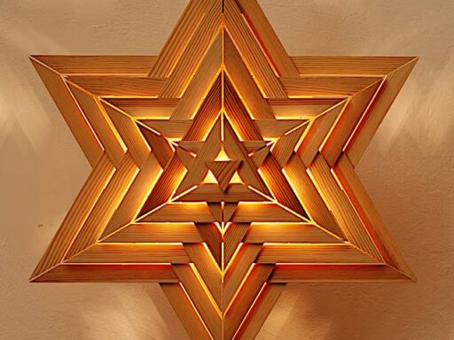 Beleuchteter Stern aus Zirbenholz an einer Wand mit warmem Licht